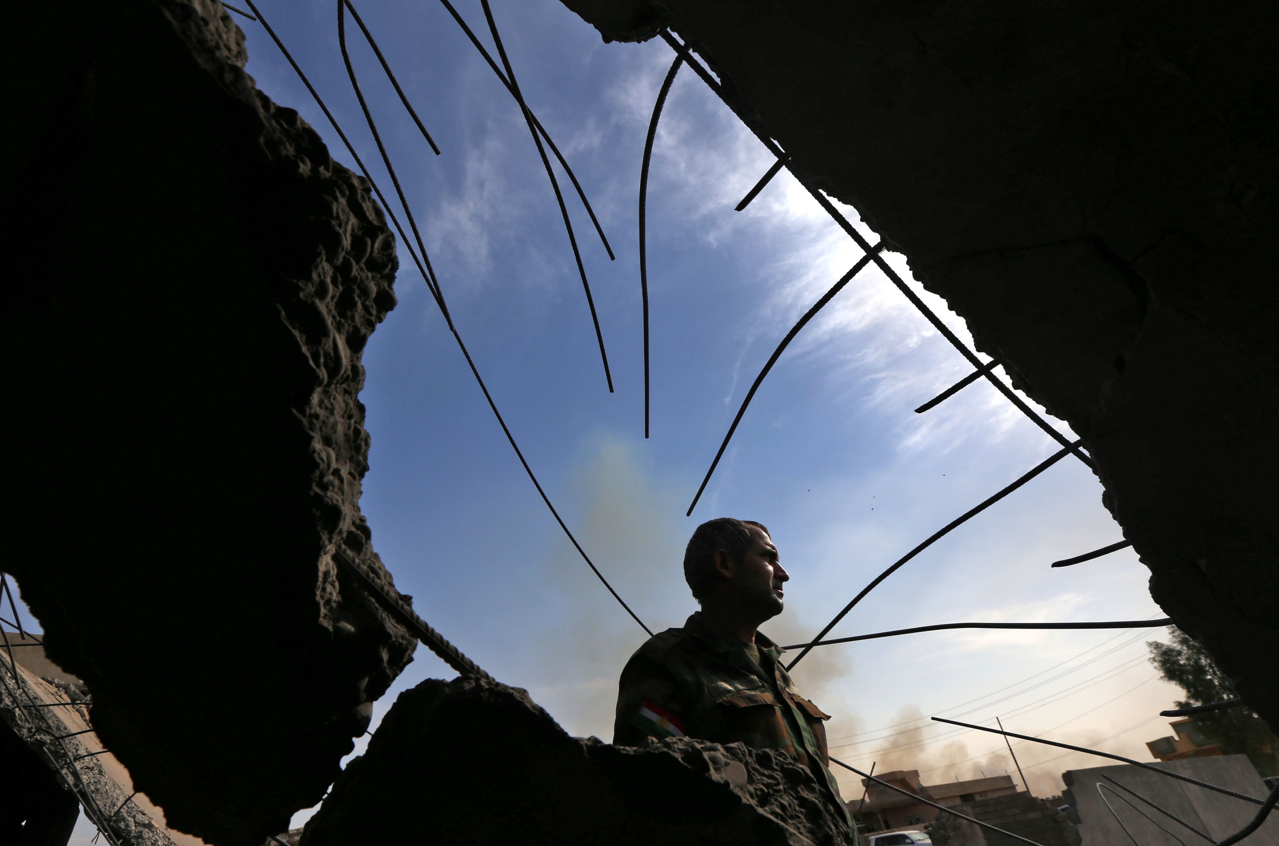 An Iraqi Kurdish Peshmerga fighter stands inside of a building on the frontline in Shaqouli village, recaptured from Islamic State fighters, some 21 miles east of Mosul on Oct. 18. 