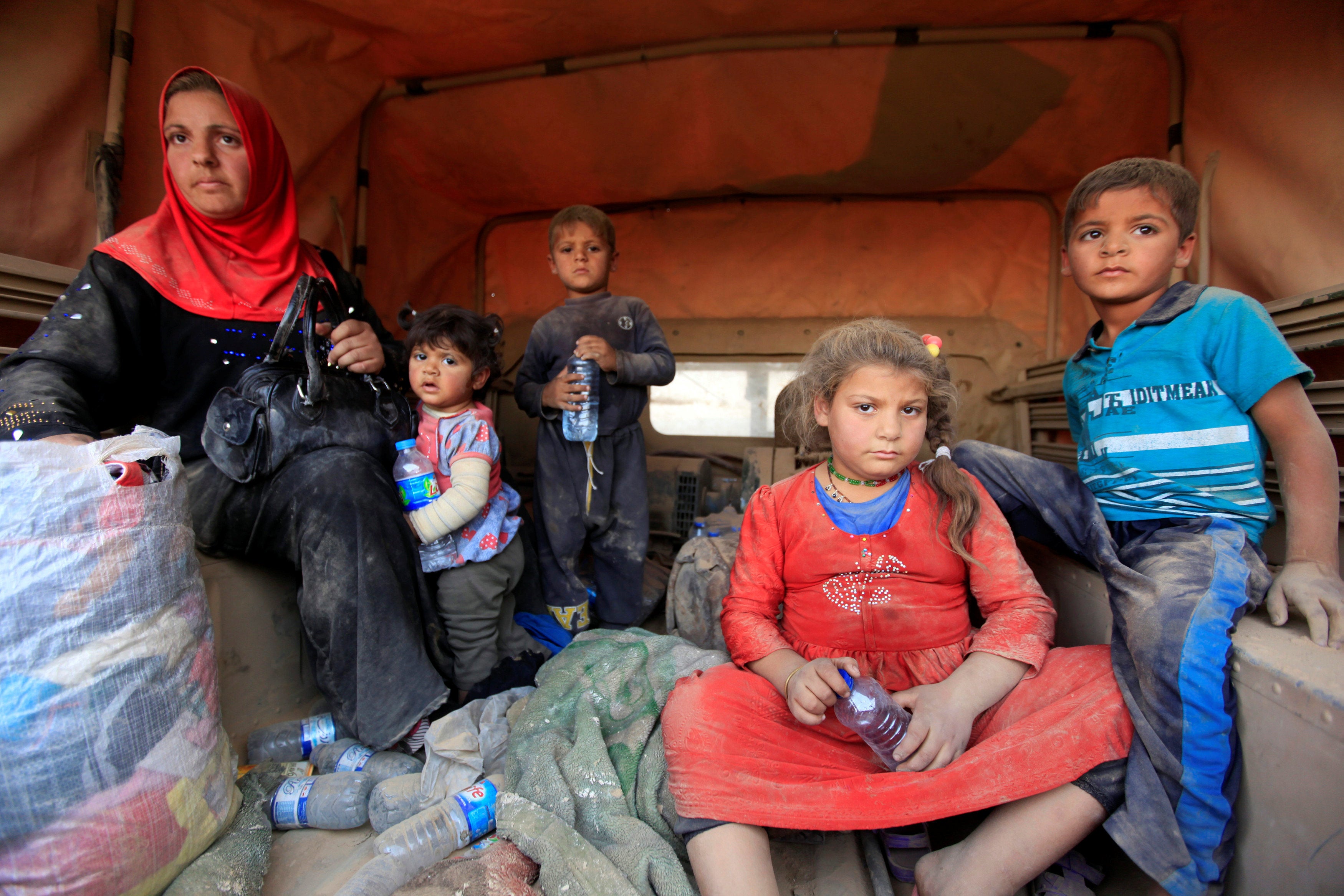 Displaced people who are fleeing from clashes inside a military vehicle in Qayyarah while an operation takes place to attack Islamic State militants in Mosul, around 19 miles north of the town.