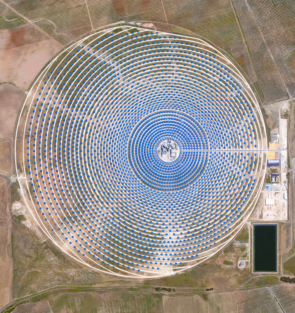 <strong>Gemasolar Thermosolar Plant</strong><br /><br /> This Overview captures the Gemasolar Thermosolar Plant in Seville, Spain. The solar concentrator contains 2,650 heliostat mirrors that focus the sun’s thermal energy to heat molten salt flowing through a 460-foot central tower. The molten salt then circulates from the tower to a storage tank, where it is used to produce steam and generate electricity. In total, the facility displaces approximately 30,000 tons of carbon dioxide emissions every year.