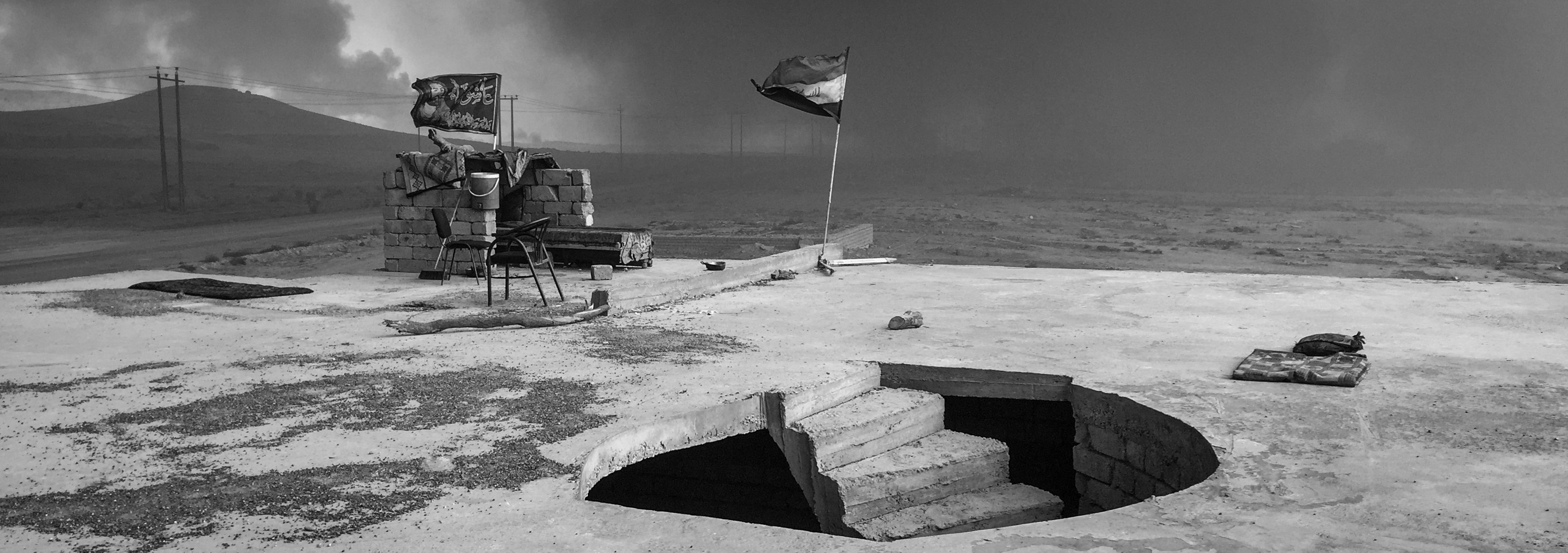 A rooftop outpost is seen under smoke filled skies from burning oil wells set on fire by fleeing ISIS members on Nov. 10, 2016, in Al Qayyarah, Iraq.