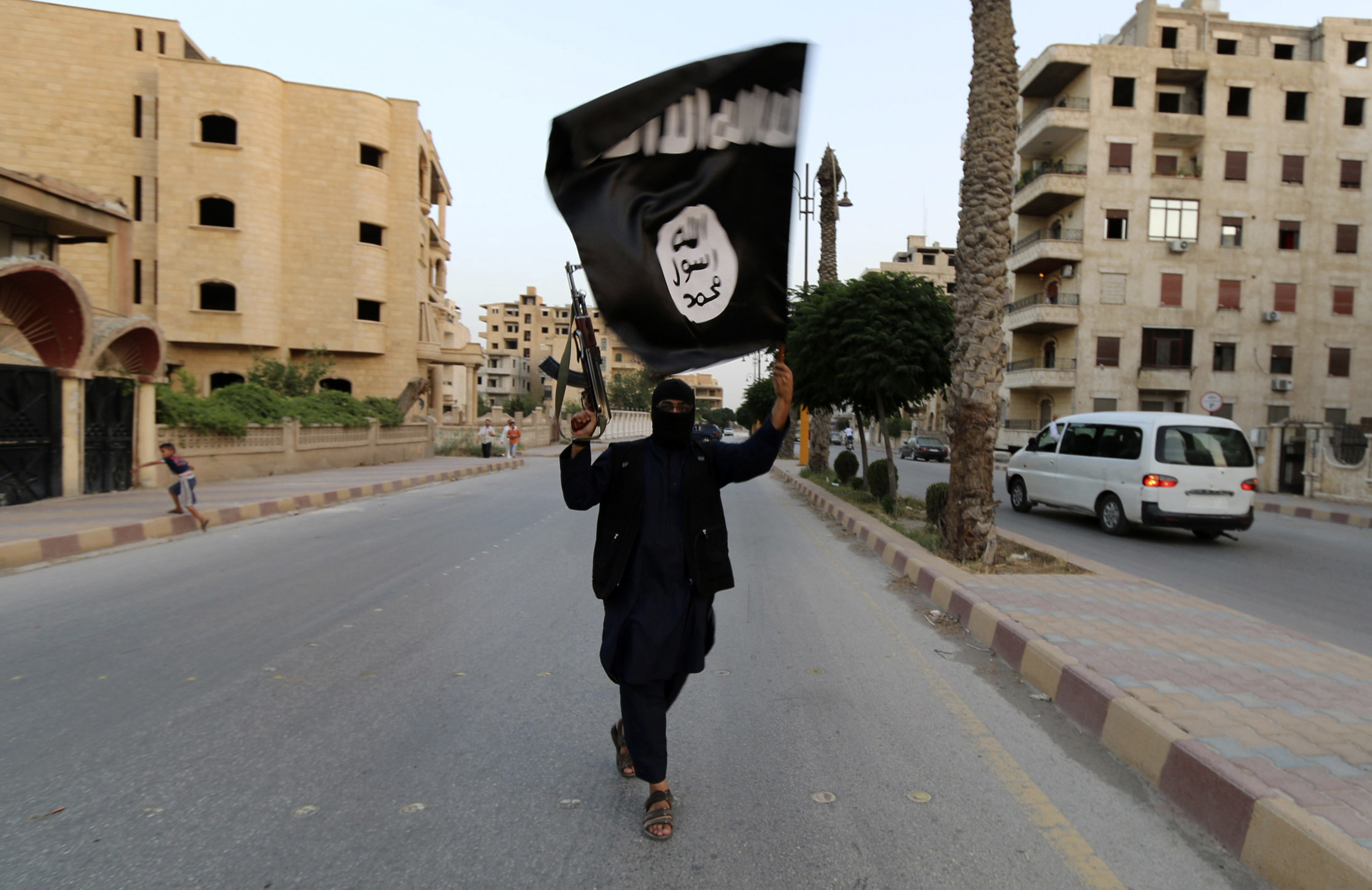 <strong>An ISIS member waves a flag in Raqqa in 2014&nbsp;</strong>