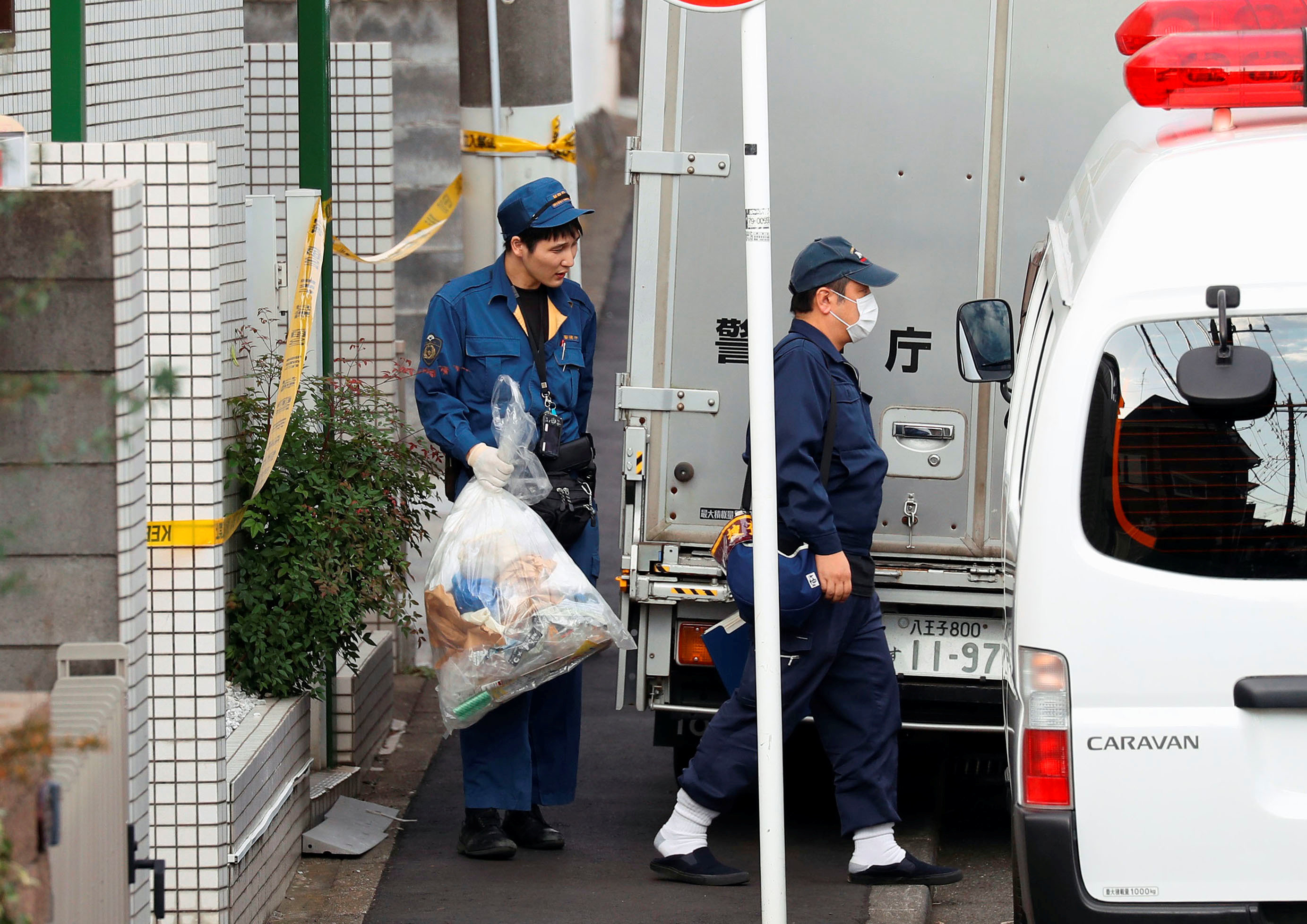 <strong>A police officer carries out a plastic bag from an apartment building after the discovery of nine bodies&nbsp;</strong>
