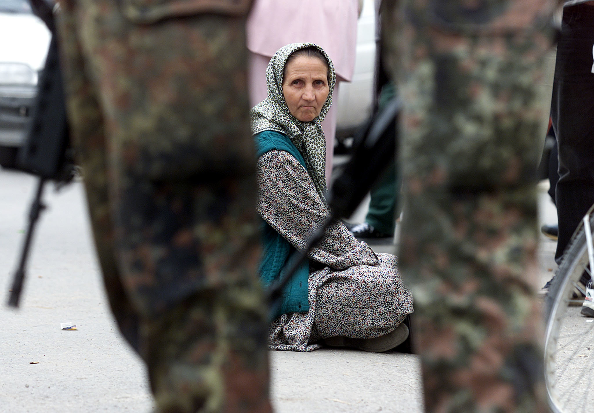 <strong>An elderly Bosnian Muslim refugee sits behind soldiers in a Sarajevo suburb in 1995</strong>