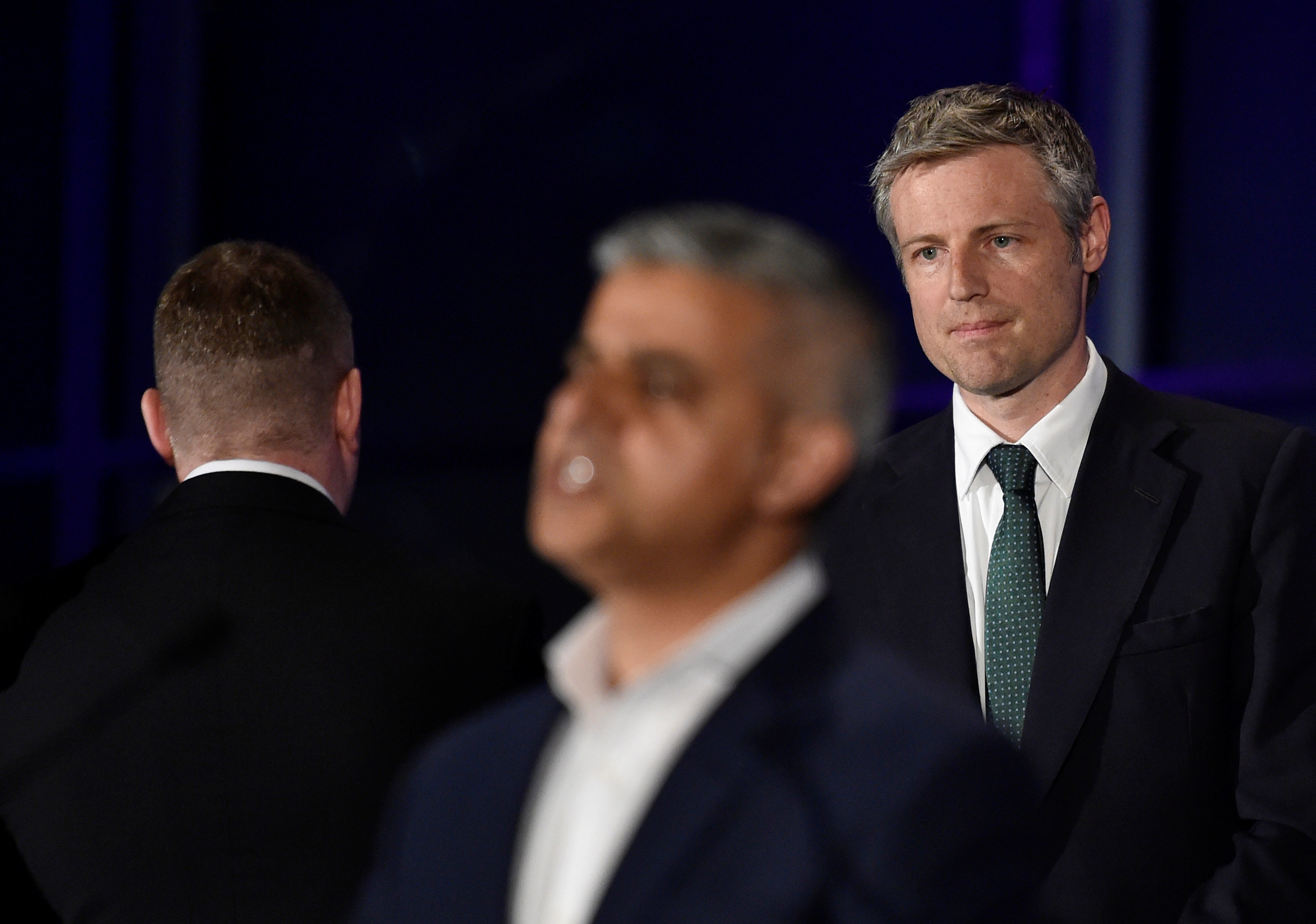 Paul Golding (left) turns his back as Sadiq Khan (centre) gives a speech having just been elected mayor of London