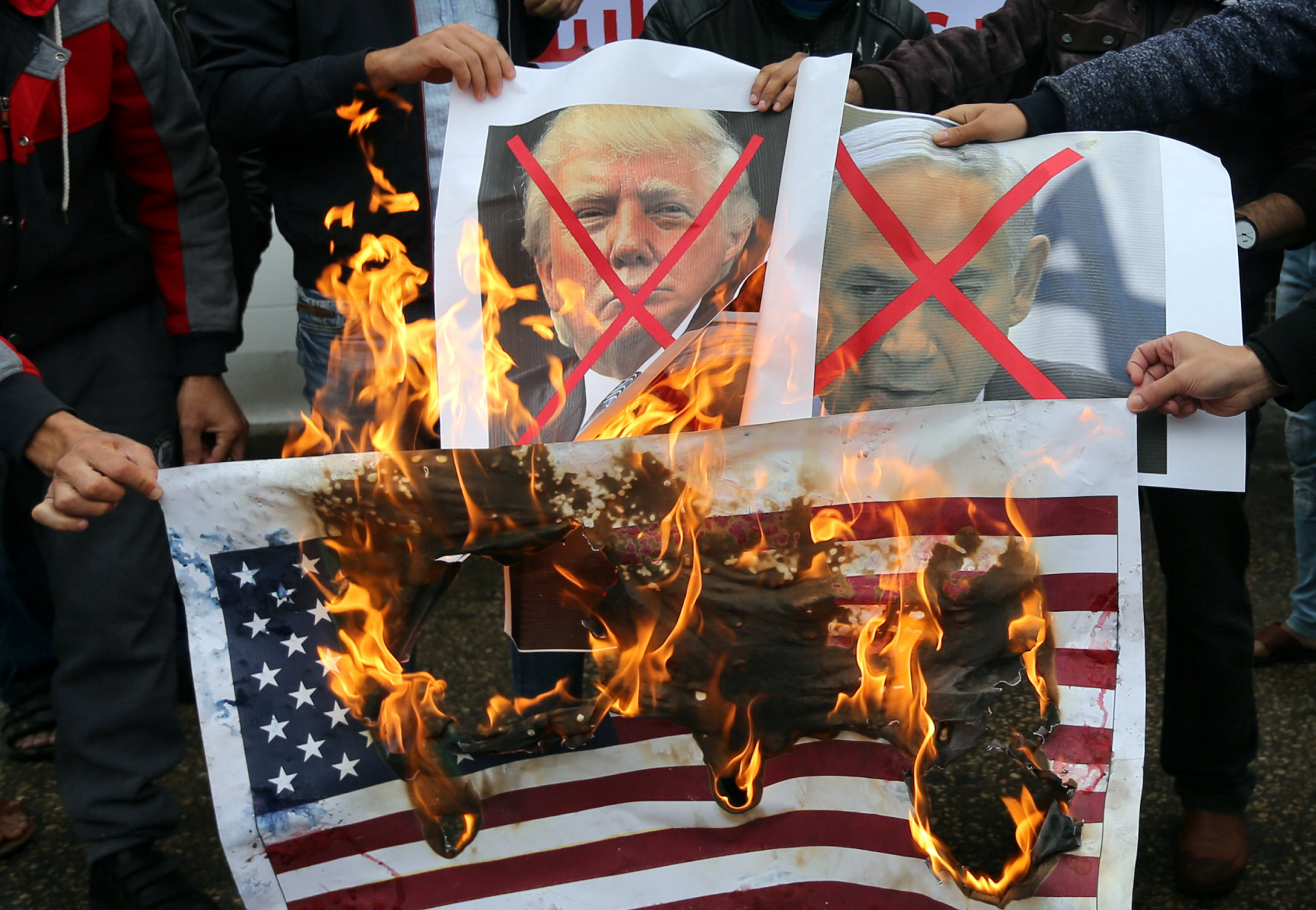 <strong>Palestinians burn posters depicting Israeli Prime Minister Benjamin Netanyahu and U.S. President Donald Trump during a protest against the U.S. intention to move its embassy to Jerusalem and to recognize the city of Jerusalem as the capital of Israel, in Rafah in the southern Gaza Strip</strong>