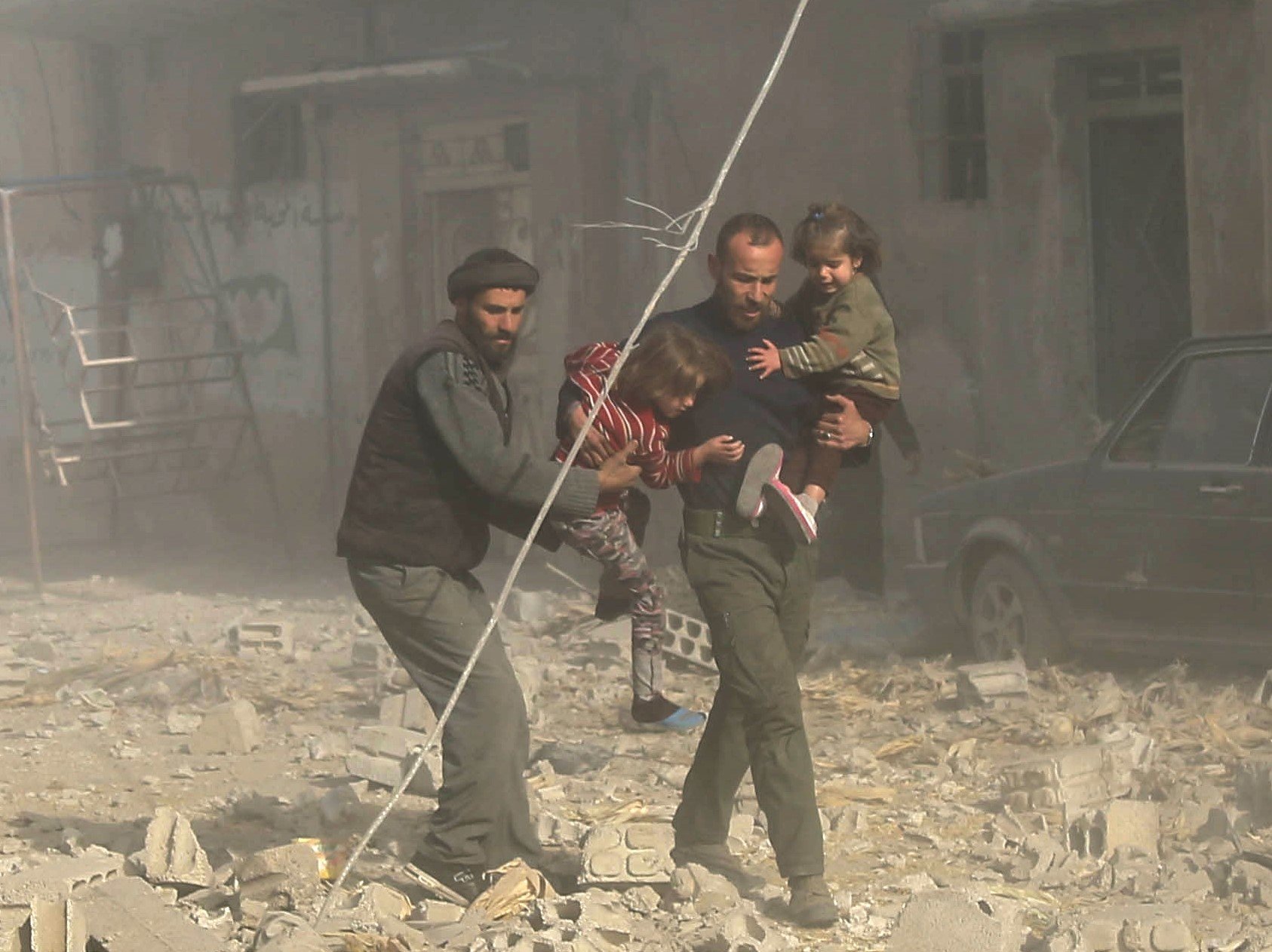 <strong>Nearly one in four civilians killed in Syria is a child, a report has found; Syrian men are seen carrying their children to safety following residential air strikes in Damascus, Syria, on December 3</strong>