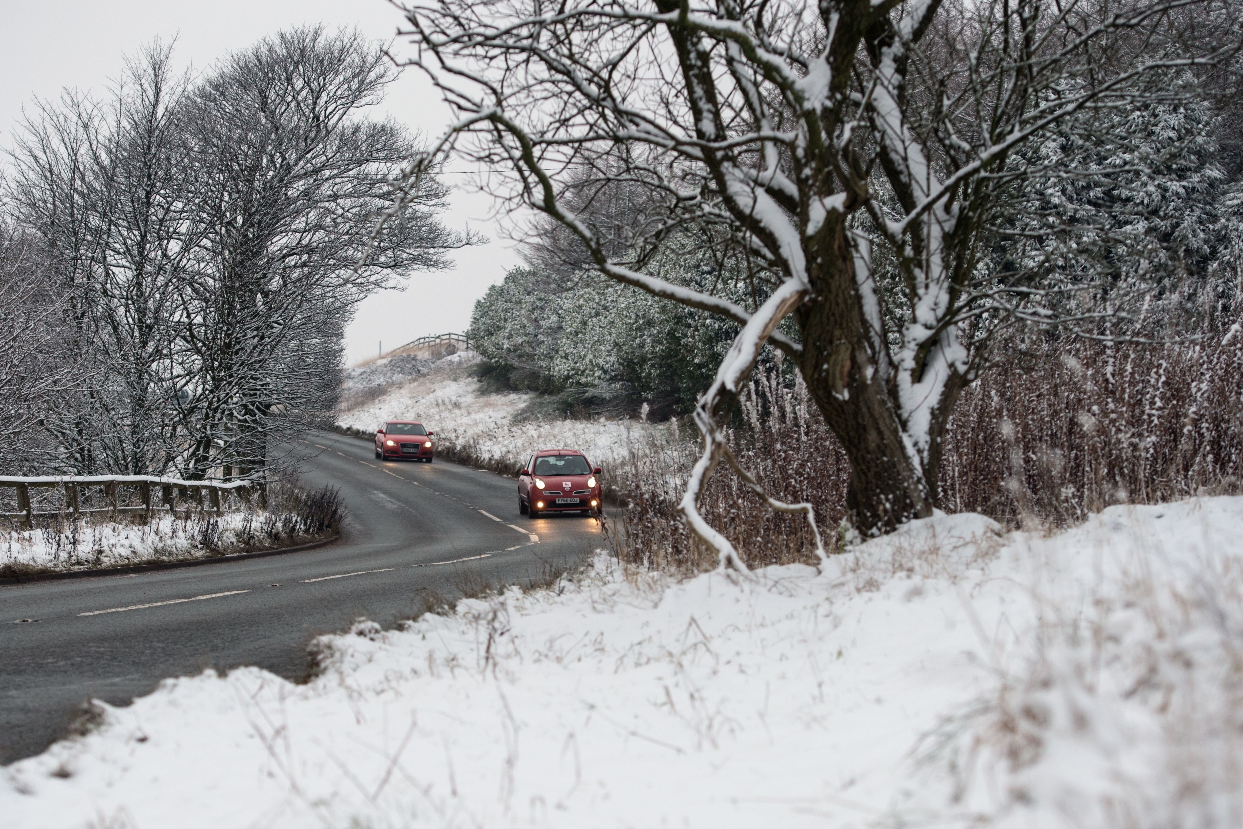 <strong>Cars travel on a cleared road near Diggle, Greater Manchester, on Sunday</strong>