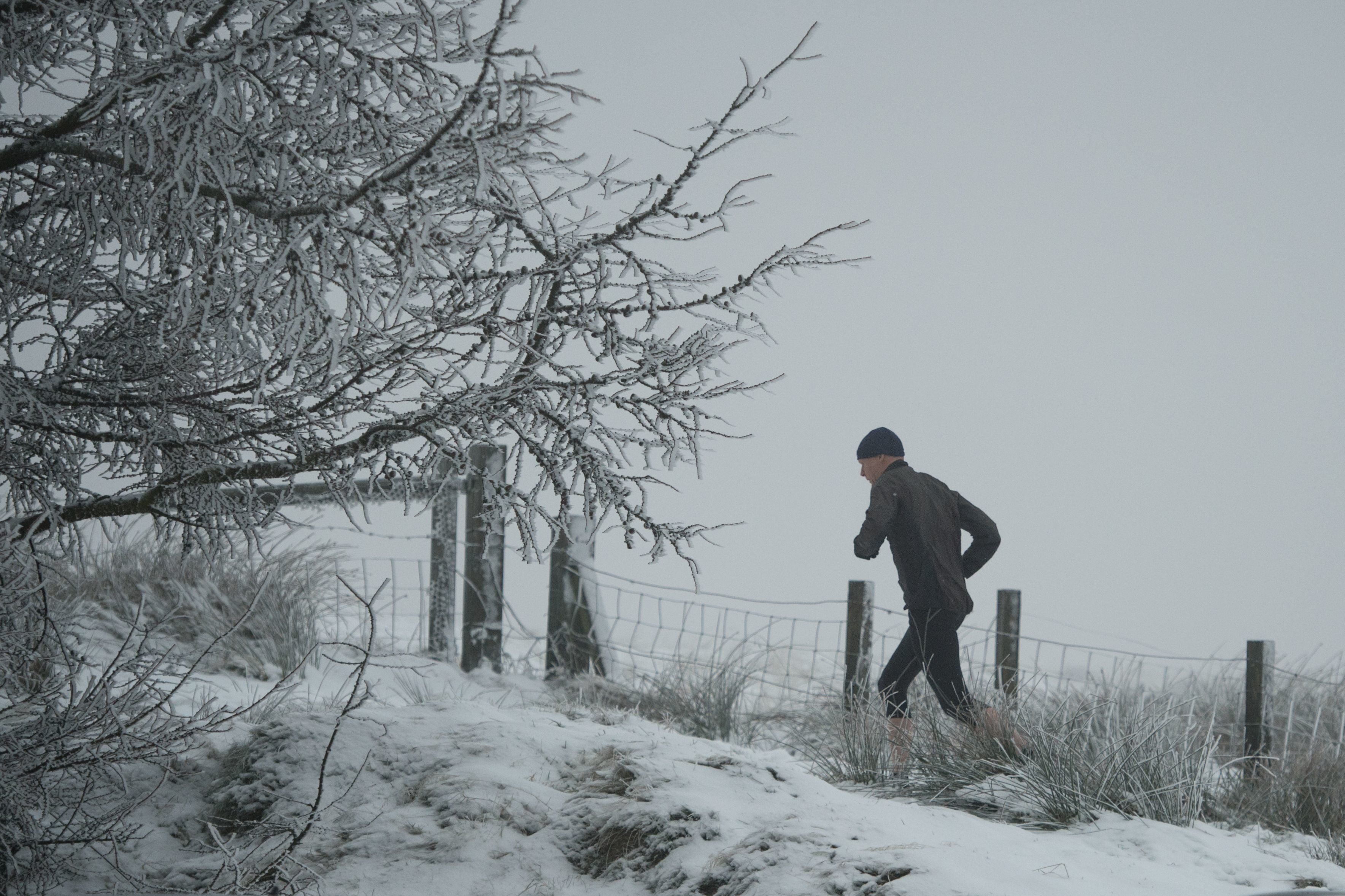 <strong>One man braved a morning run on Sunday amid snow-covered hills in Greater Manchester</strong>
