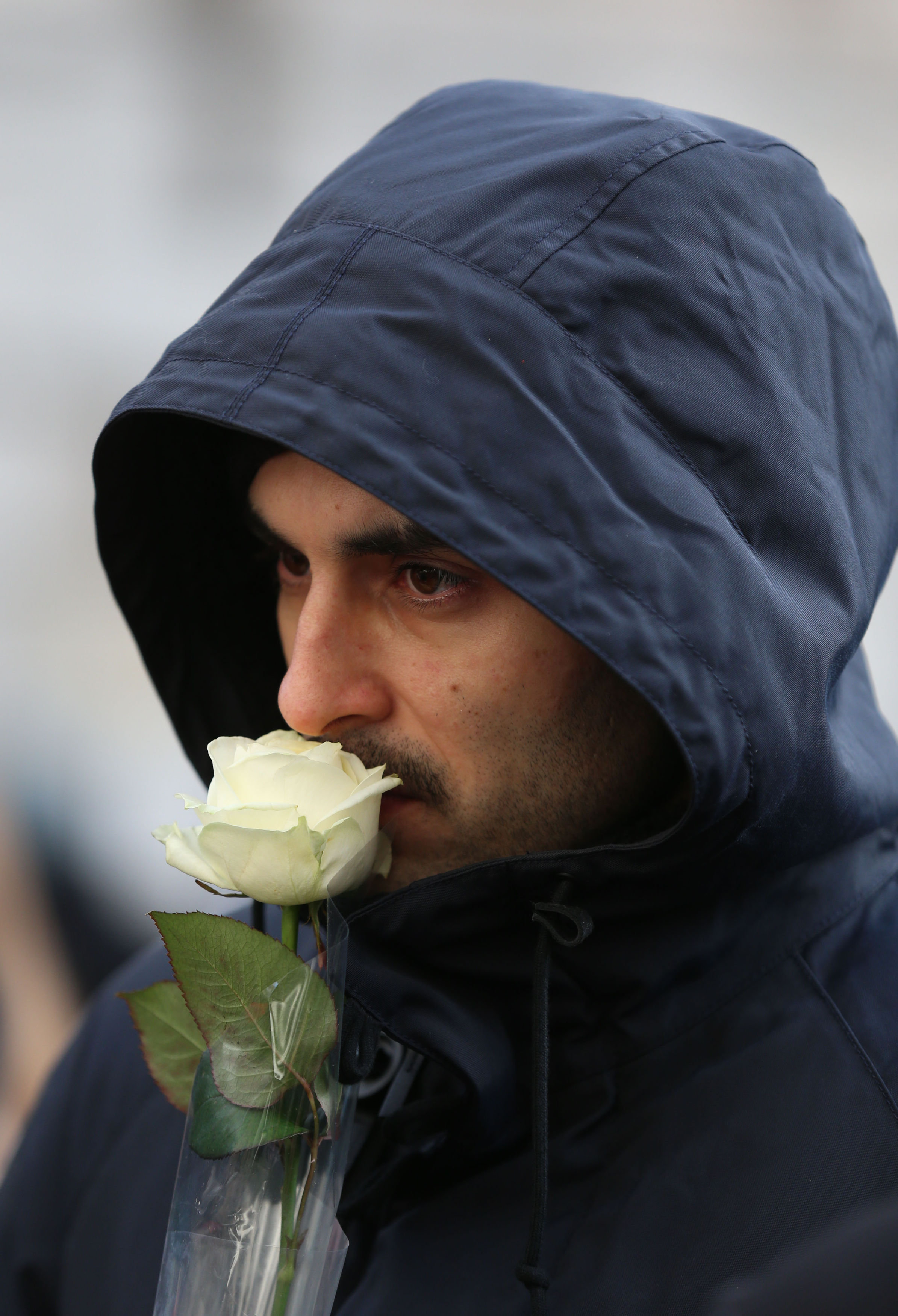 &nbsp;A man holds a white rose as he leaves the service&nbsp;