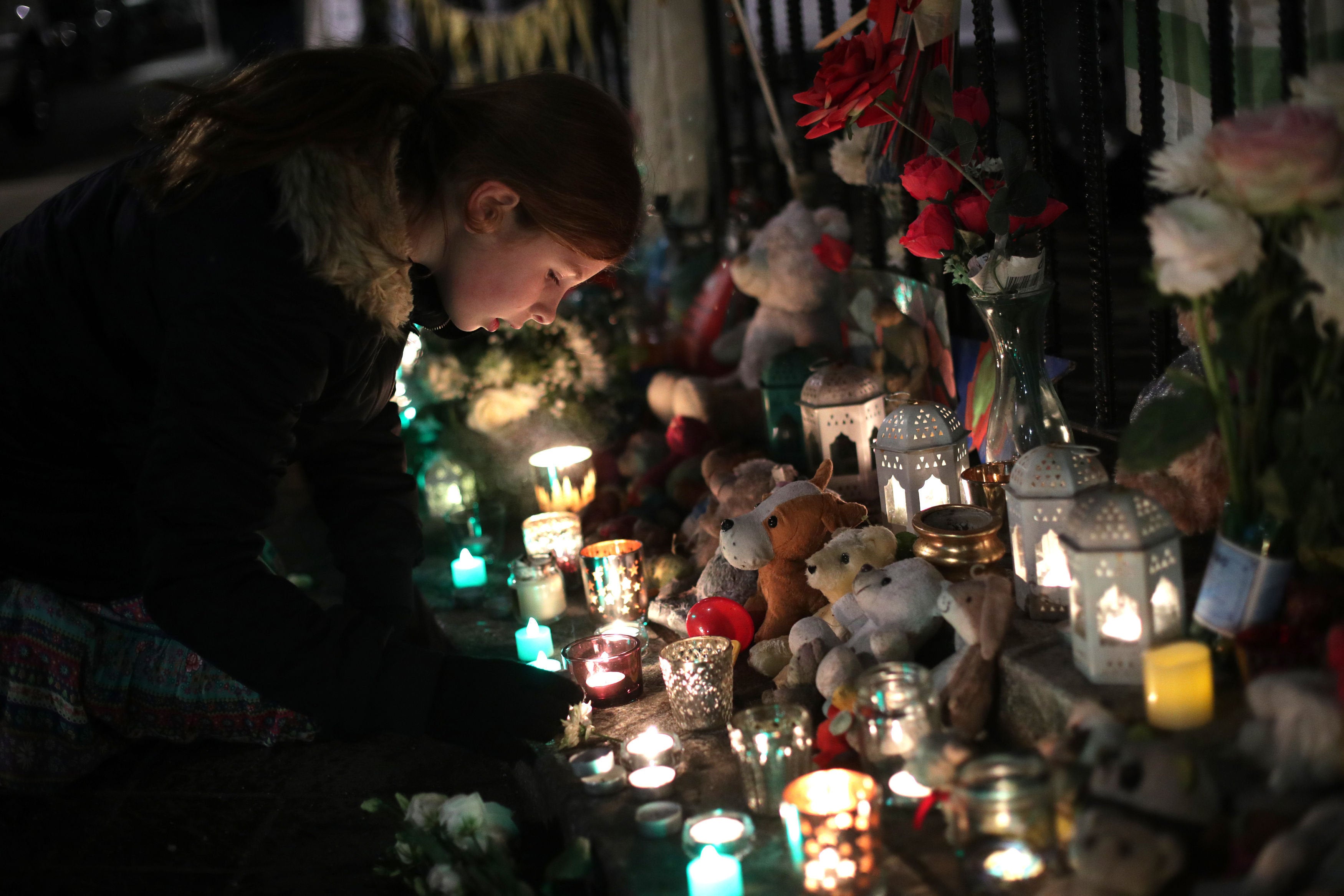 <strong>A woman lays a candle during the silent walk to march the six month anniversary of the Grenfell fire.</strong>