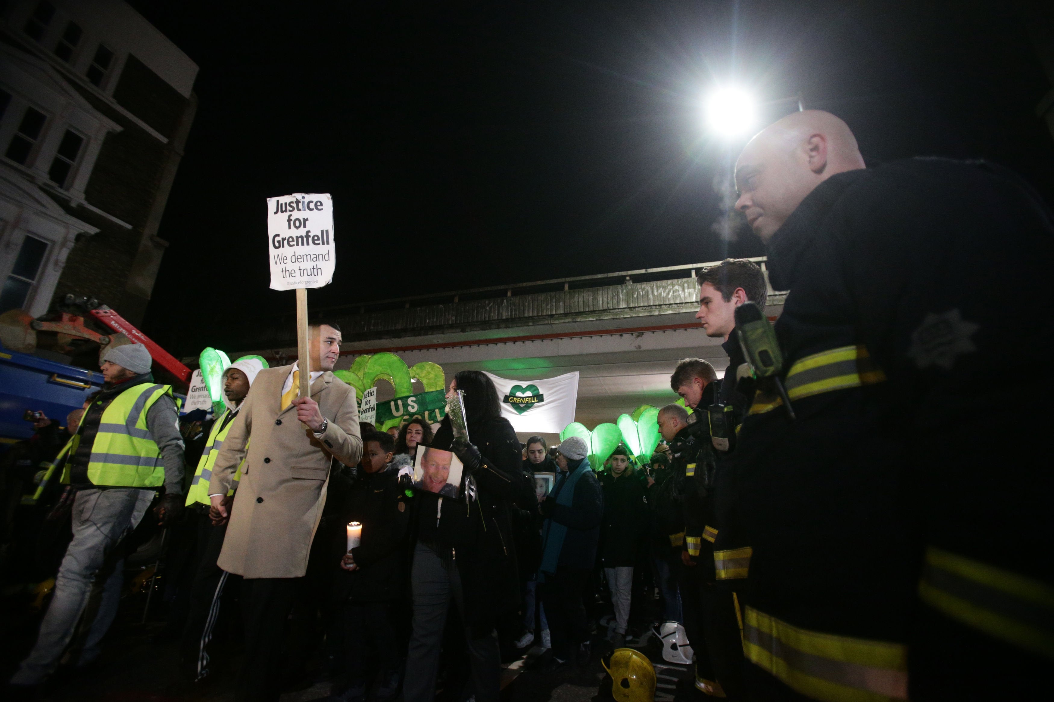 <strong>Marchers pass firefighters paying their respects at the Grenfell silent walk.</strong>