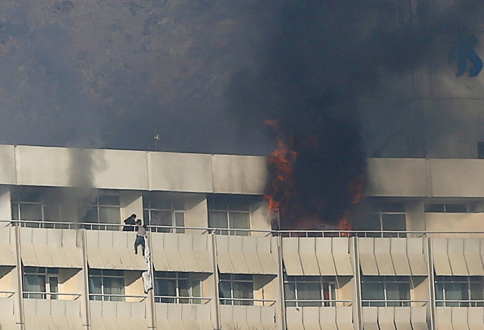 <strong>A man tries to escape from a balcony at Kabul's Intercontinental Hotel during the siege</strong>