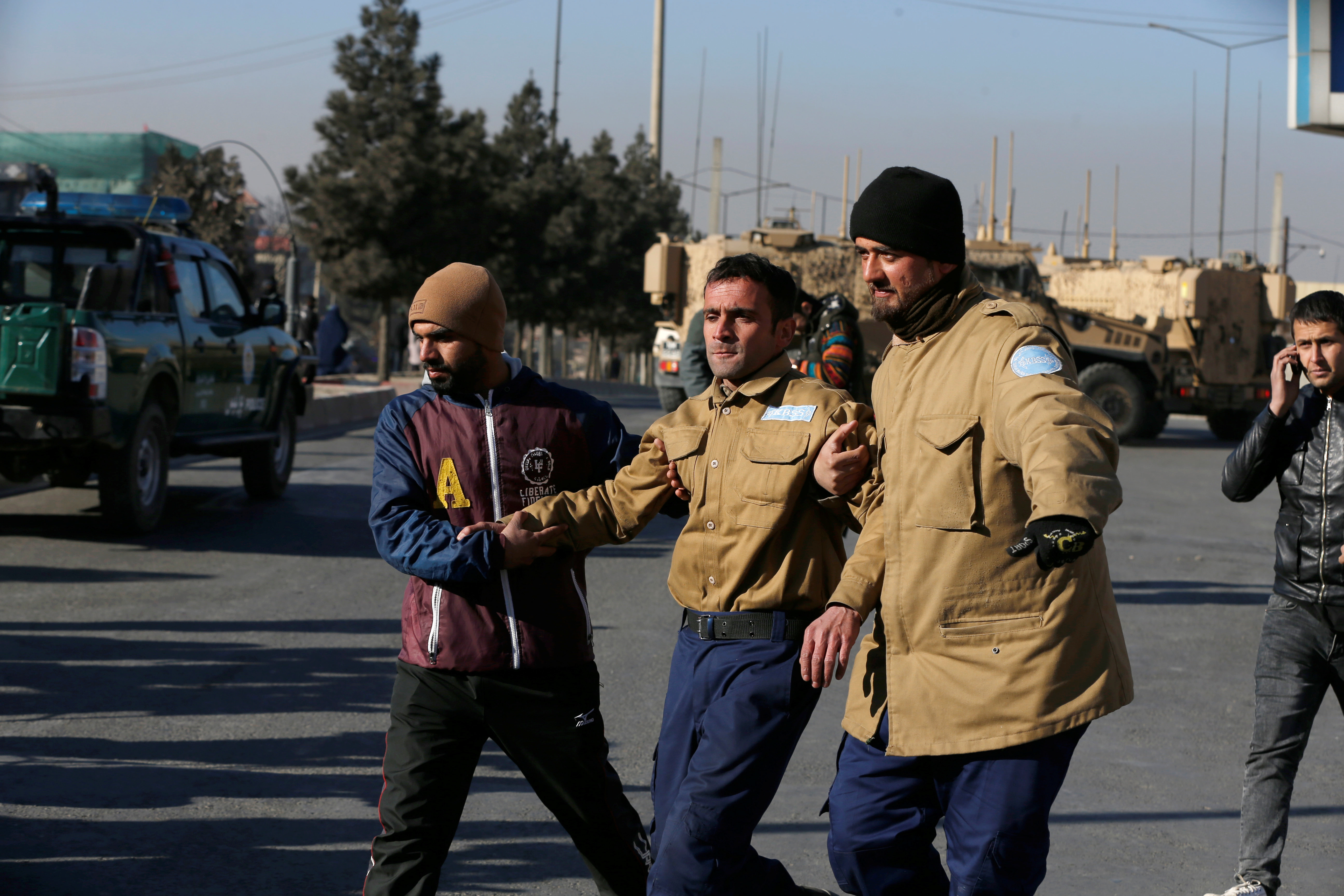 <strong>A wounded security guard is helped from the scene of the siege</strong>