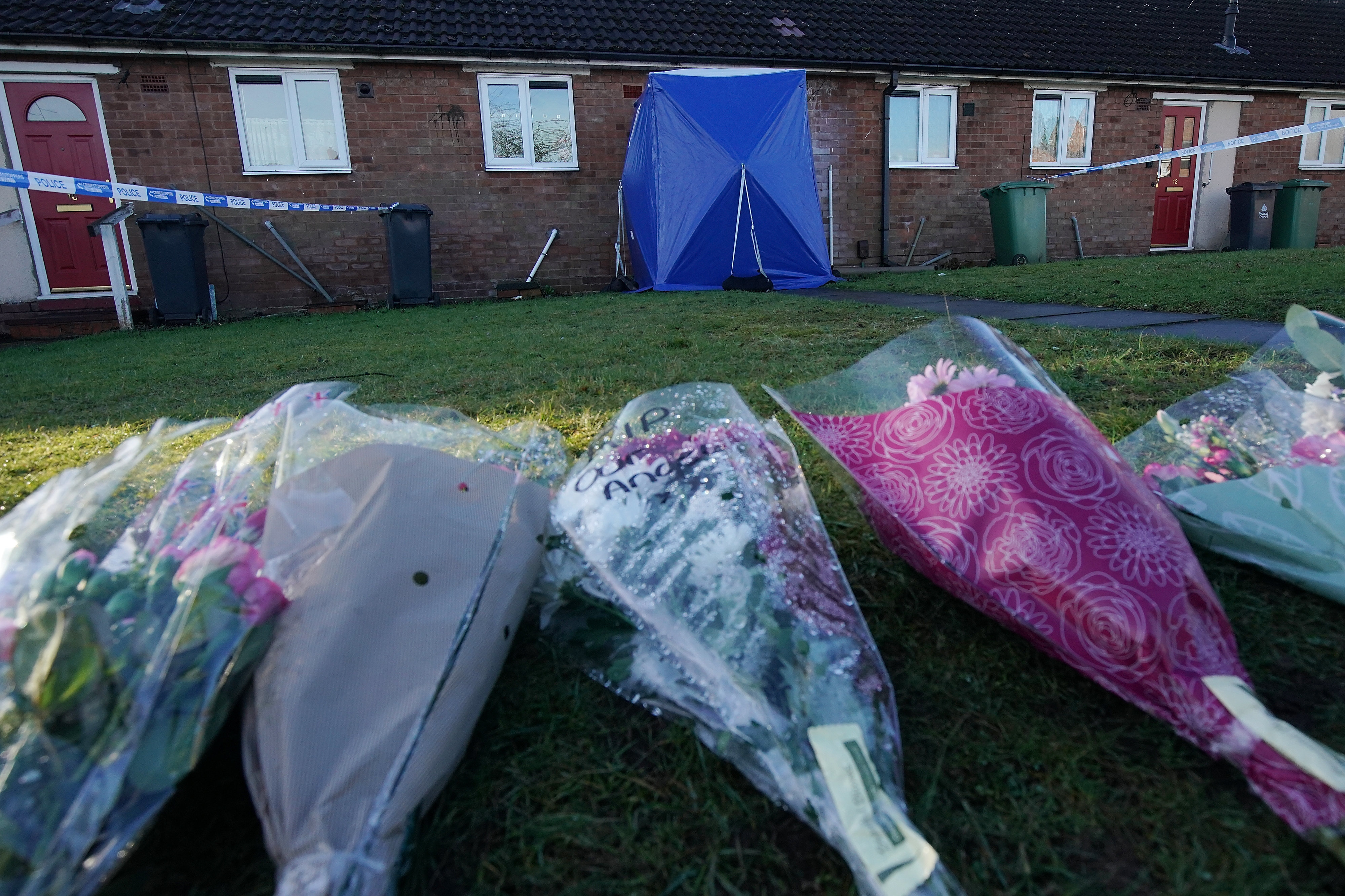 <strong>A police tent and floral tributes outside the home where Mylee was stabbed&nbsp;</strong>