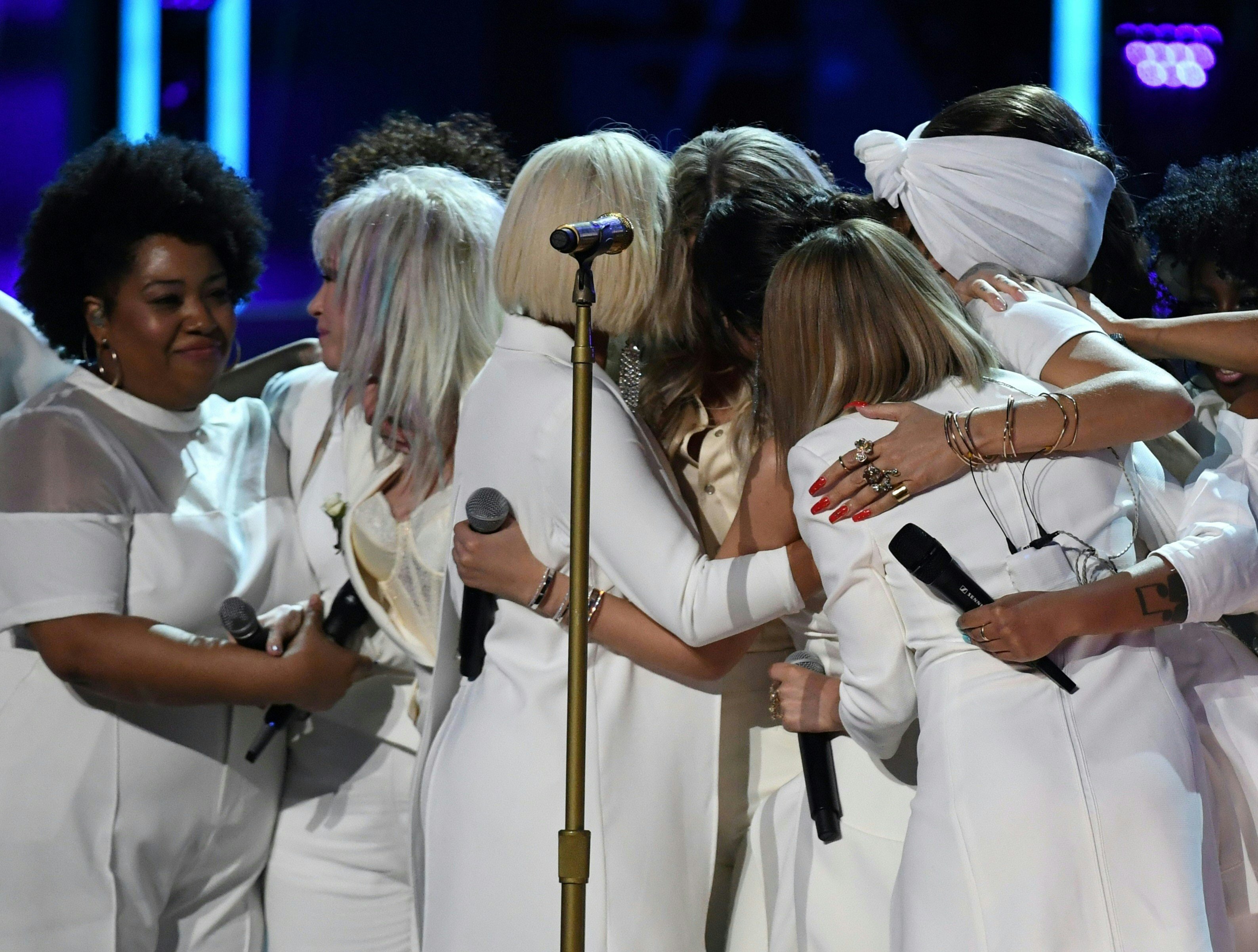 <strong>The women on stage embrace</strong>