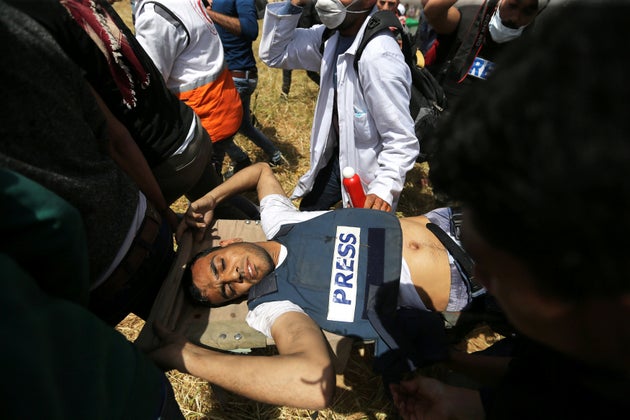 Mortally wounded Palestinian journalist Yasser Murtaja is evacuated during clashes at the Israel-Gaza border on April 6, 2018.
