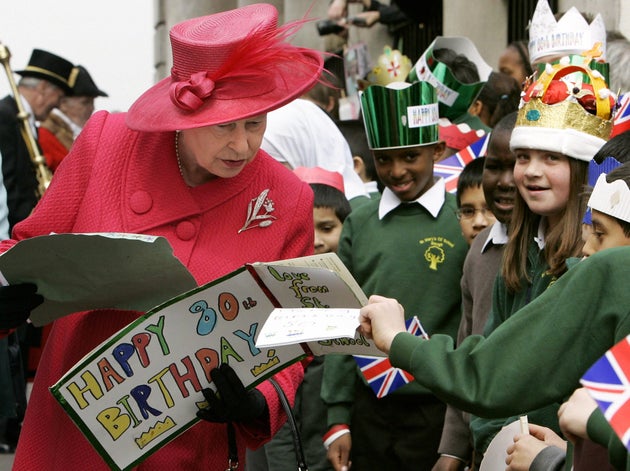 The Queen collects handmade cards from schoolchildren during a walkabout to celebrate her 80th birthday in Windsor