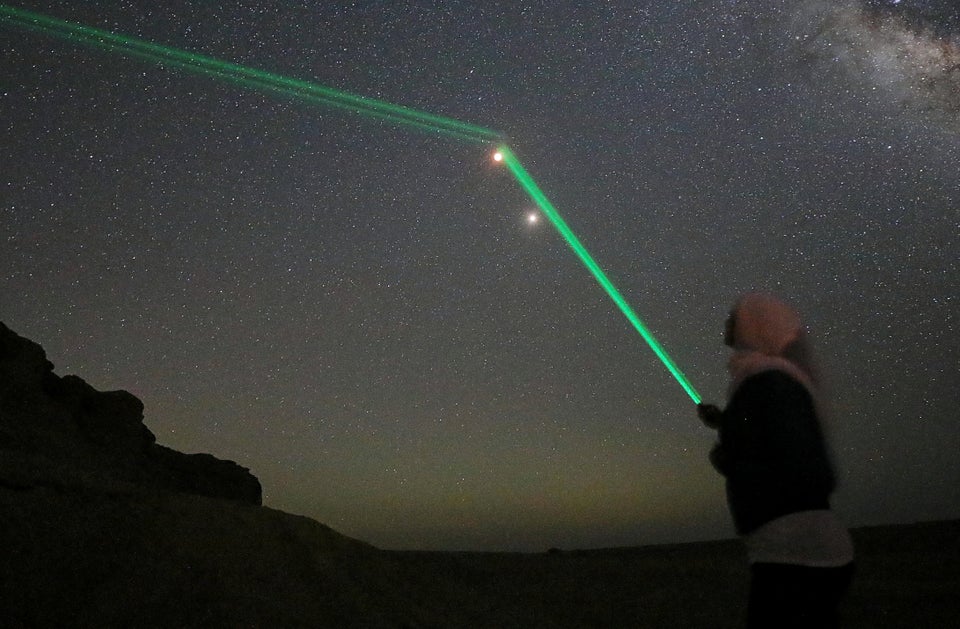 People shine laser lights towards the moon in the desert of Al Fayoum Governorate, south-west of Cairo, Egypt.