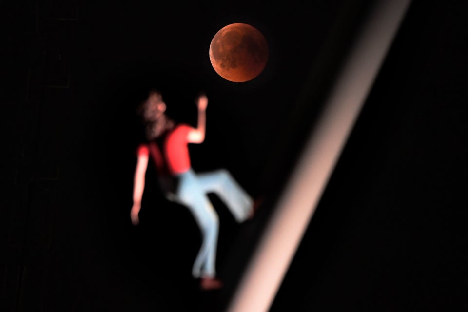 The eclipse alongside a sculpture by American artist Jonathan Borofsky in Strasbourg, eastern France.