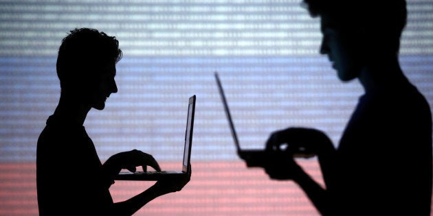 People pose with laptops in front of a screen projected with the Russian national flag, in Zenica, Bosnia and Herzegovina, Oct. 29, 2014.