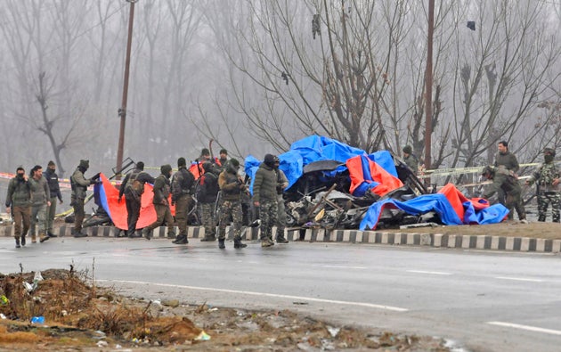 Security personnel inspect the blast site in Pulwama.