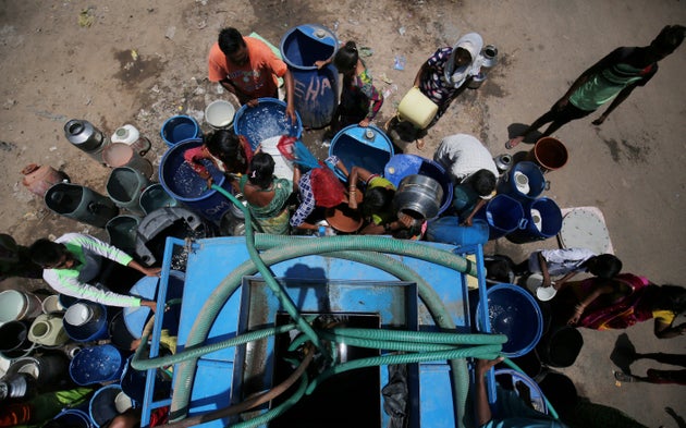 People fill their empty containers with water from municipal corporation tanker in Ahmedabad.