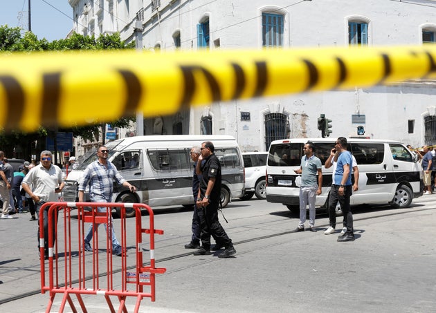 Un grupo de agentes y civiles, en el lugar donde se ha producido el ataque contra el convoy policial.