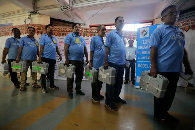Election officials carry electronic voting machines for counting votes of in the general elections in Ahmadabad, May 23, 2019.