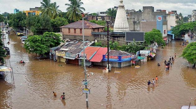 In this picture taken on August 6, 2019 people wade through a flood street in Sangli district of Maharashtra