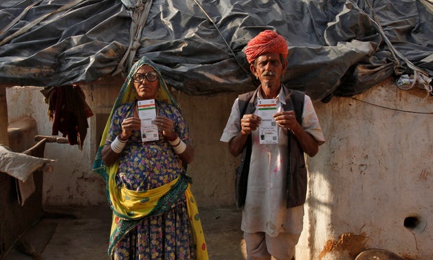 Ghewar Ram (R), 55, and his wife Champa Devi, 54, display their Unique Identification (UID) cards outside their hut at Merta district in the desert Indian state of Rajasthan February 21, 2013.