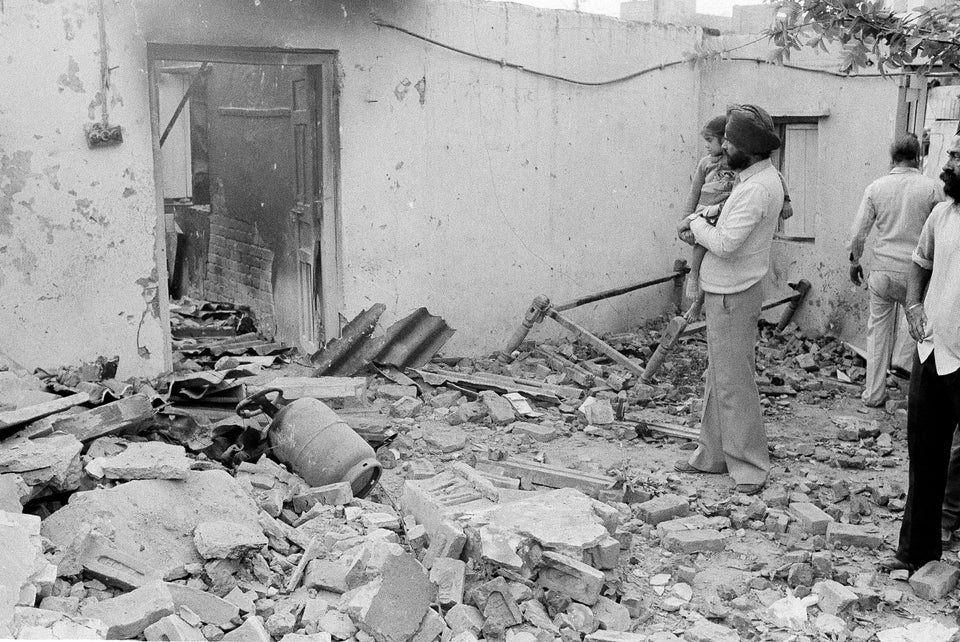 A Sikh man looks at the smashed door and the rubble in front of his house in New Delhi, 2 November, 1984.