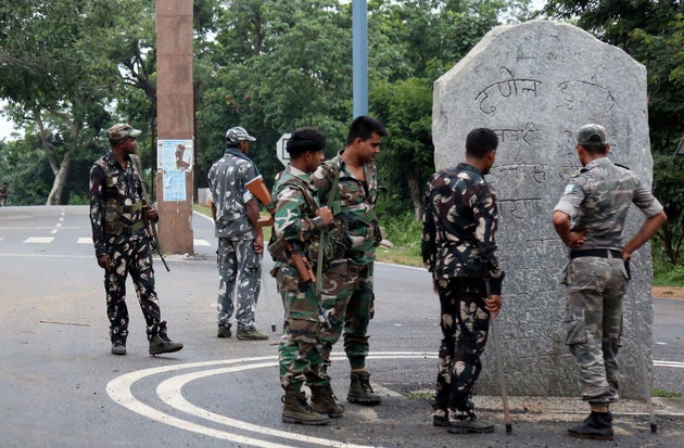 This photo taken on June 26, 2018 shows Indian security forces looking at stone monoliths displaying an allegiance to Pathalgadi -- a popular indigenous tribal movement -- at the entrance to a tribal-dominated region in Khunti district in India's eastern Jharkhand state.