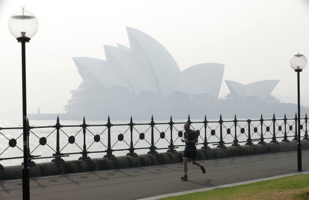 A jogger runs in the morning as smoke haze hangs over the Sydney Opera House in Sydney, on Nov. 21, 2019.