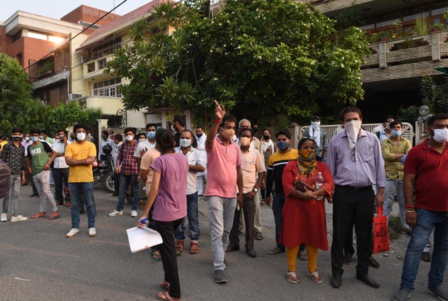 People wait for NEET outside the examination centre at Summer Fields School in Kailash Colony, on September 13, 2020, in New Delhi.