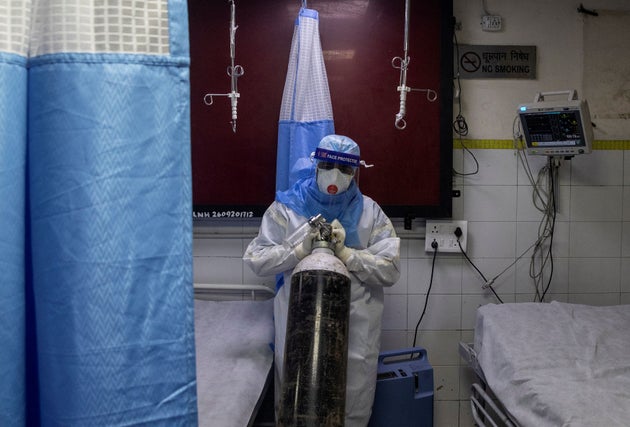 A medical worker wearing PPE pushes an oxygen cylinder at the casualty ward in Lok Nayak Jai Prakash (LNJP) hospital, in New Delhi, July 17, 2020.