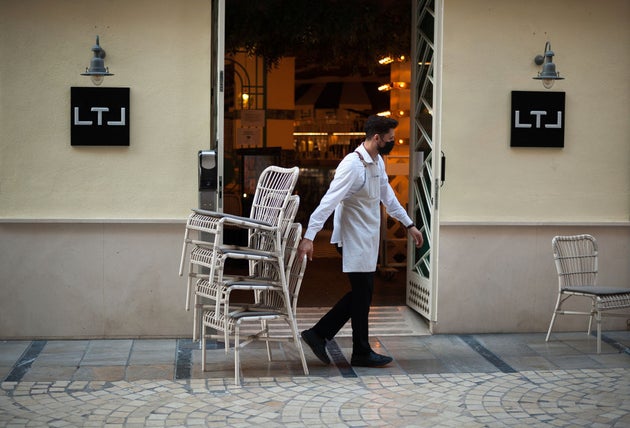 Un camarero coloca sillas en el restaurante Strachan de Málaga.