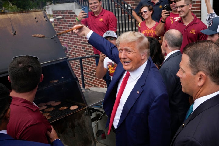 Former President Donald Trump holds a spatula with a hamburger on it as he works the grill during a stop at the Alpha Gamma Rho, an agricultural fraternity at Iowa State University on Sept. 9.