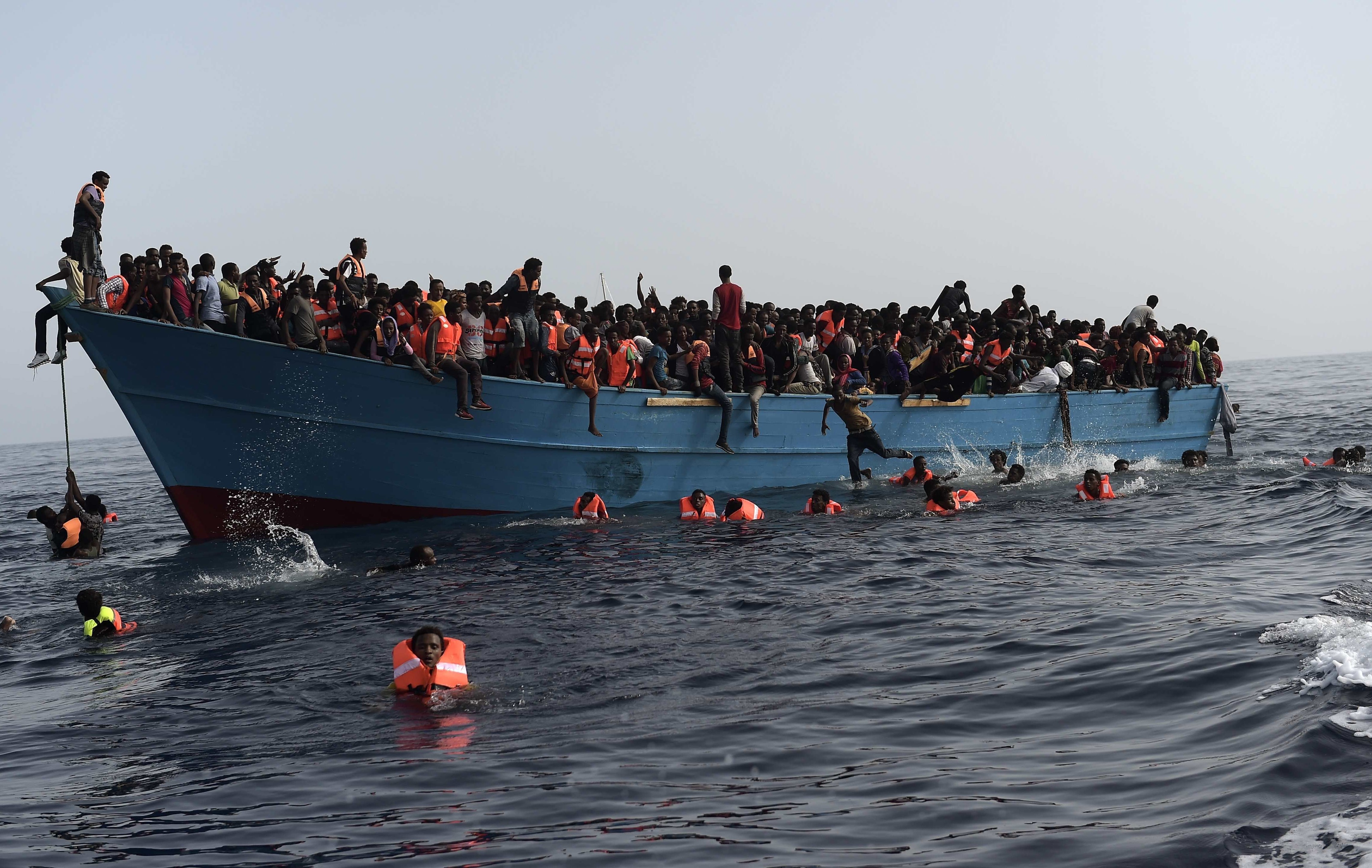 Refugees and migrants wait to be rescued by members of Proactiva Open Arms NGO in the Mediterranean Sea, some 12 miles north of Libya, on Oct. 4.