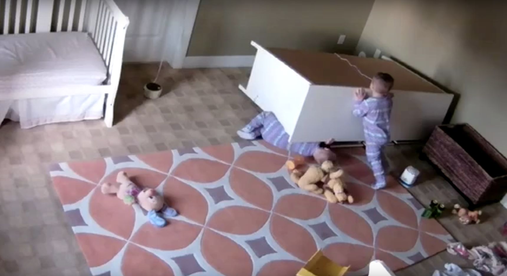 The 2-year-old boy is seen pushing a dresser off of his twin brother after it toppled on him in their bedroom last week.