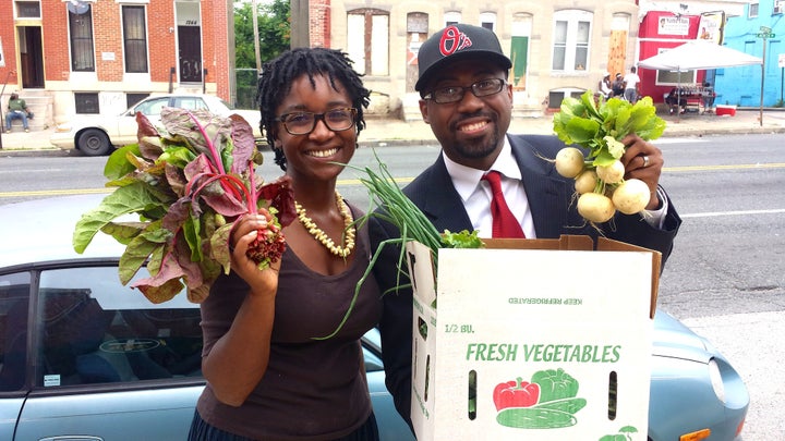 <p>Rev. Heber Brown III and Aleya Fraser, co-founder of Black Dirt Farm, hold up produce from the farm.</p>
