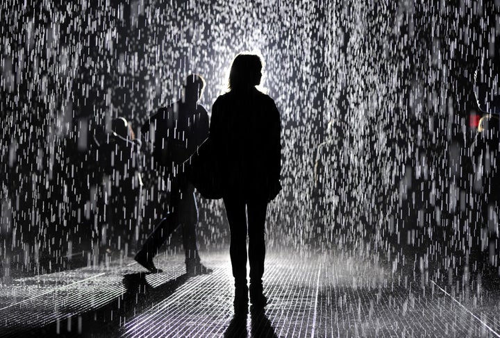 A visitor at the 'Rain Room' at MoMA on May 20, 2013, in New York City. A large-scale environment by Random International, Ra