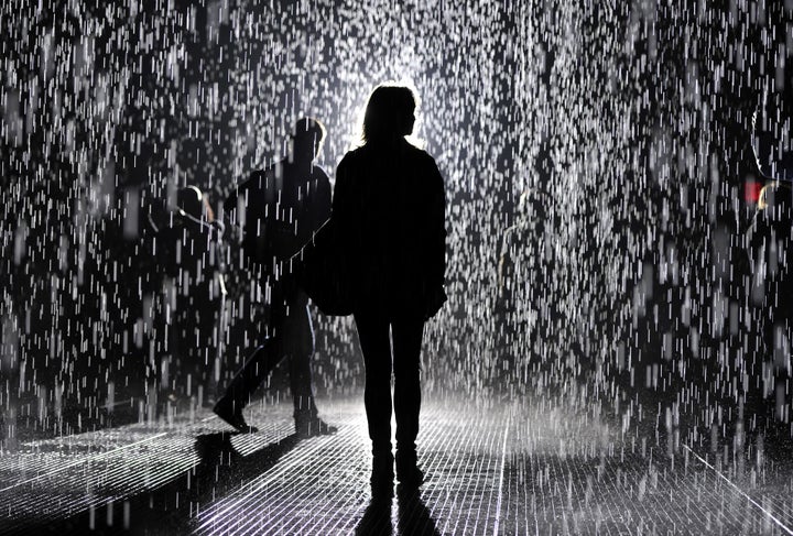 A visitor at the 'Rain Room' at MoMA on May 20, 2013, in New York City. A large-scale environment by Random International, Rain Room is a field of falling water that pauses wherever a human body is detected, offering visitors the experience of controlling the rain. (TIMOTHY CLARY/AFP/Getty Images)