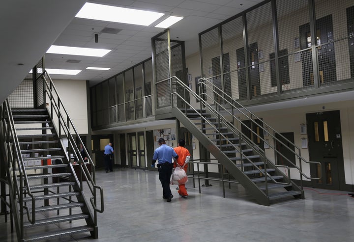 A guard escorts an immigrant detainee from his 'segregation cell' back into the general population at the Adelanto Detention Facility on November 15, 2013 in Adelanto, California.