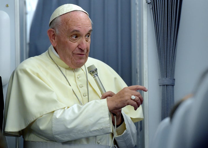 Pope Francis gestures to journalists during a press conference on July 13, 2015, onboard a plane on his way back to Rome from Paraguay, the final stop of his South America tour. Pope Francis departed Paraguay , bringing to a close a weeklong visit where he drew attention to the poor and marginalized in some of the region's poorest nations. AFP PHOTO / VINCENZO PINTO (Photo credit should read VINCENZO PINTO/AFP/Getty Images)