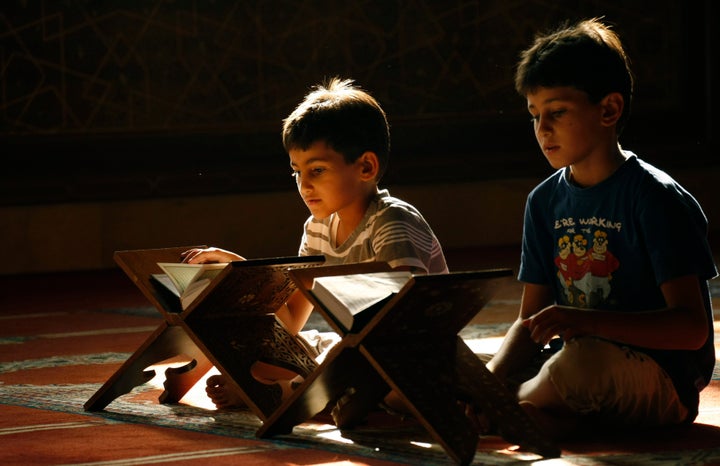 Lebanese Muslim boys read from the Koran, Islam's holy book, during the holy fasting month of Ramadan, at a mosque in the southern Lebanese city of Sidon, on Laylat al-Qadr, or Night of Destiny, when Muslims believe the first verses of the Koran were revealed to the Prophet Mohammed, on August 14, 2012. AFP PHOTO / MAHMOUD ZAYYAT (Photo credit should read MAHMOUD ZAYYAT/AFP/GettyImages)