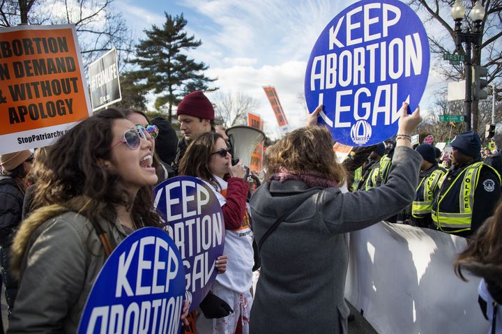 Pro-choice activists block the road against US Capitol Police, who are escorting the March For Life's path, in front of the US Supreme Court in Washington, DC, January 22, 2015. Tens of thousands of Americans who oppose abortion are in Washington for the annual March for Life, marking the 42nd anniversary of the Supreme Court's Roe v. Wade decision. AFP PHOTO/JIM WATSON (Photo credit should read JIM WATSON/AFP/Getty Images)