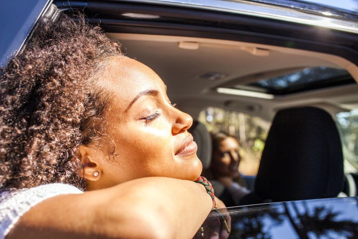 Black woman leaning out car window