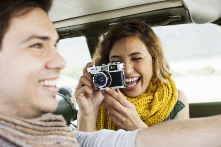 Young woman photographing boyfriend whilst driving, Cape Town, Western Cape, South Africa