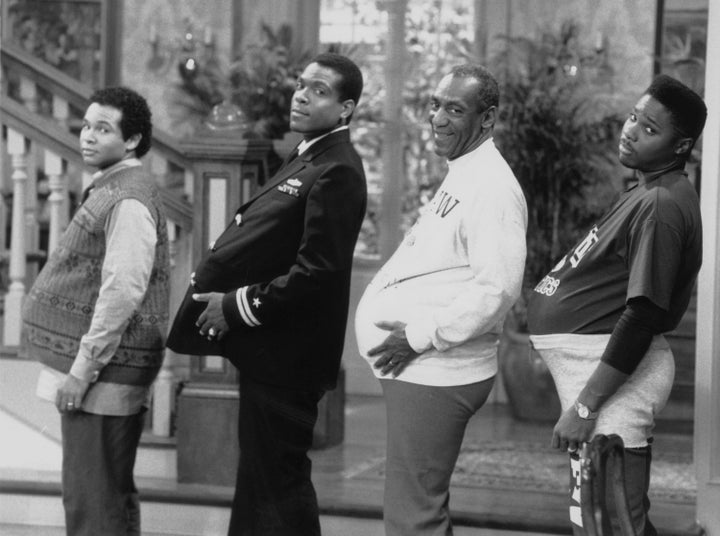 THE COSBY SHOW -- "The Day the Spores Landed" Episode 8 -- Air Date 11/09/1989 -- Pictured: (l-r) Geoffrey Owens as Elvin Tibideaux, Joseph C. Phillips as Lt. Martin Kendall, Bill Cosby as Dr. Heathcliff 'Cliff' Huxtable, Malcolm-Jamal Warner as Theodore 'Theo' Huxtable (Photo by NBC/NBCU Photo Bank via Getty Images)