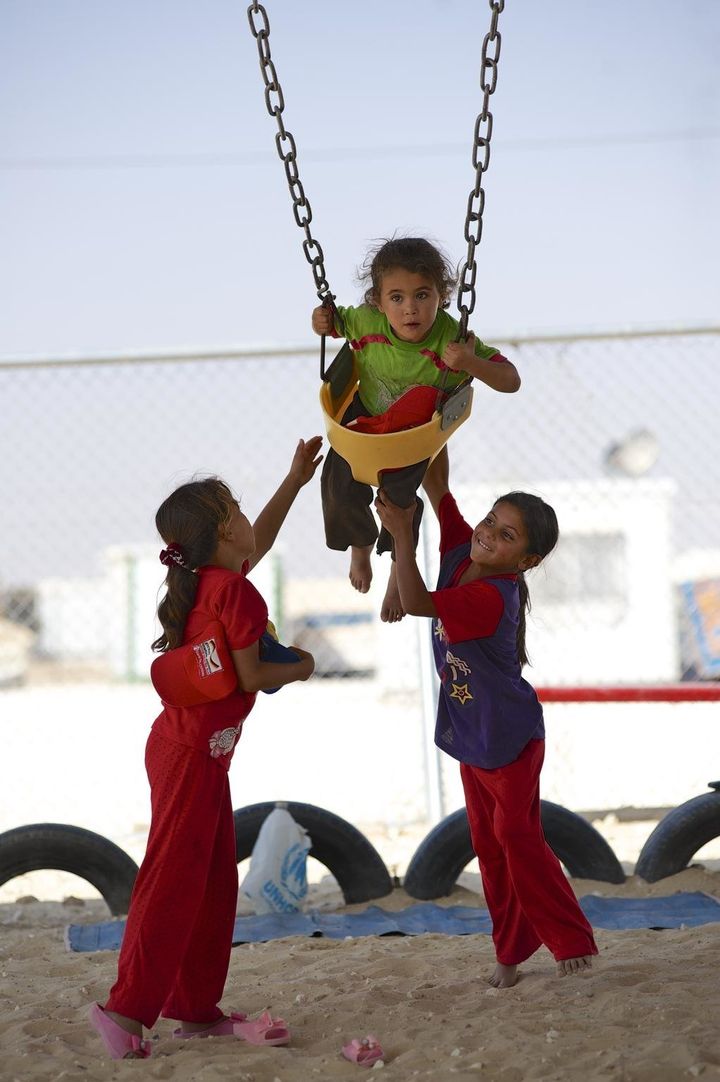 Girls play on a swing at a UNICEF-supported playground in the Zaâatari camp for Syrian refugees, in Mafraq Governorate, near the Syrian border.